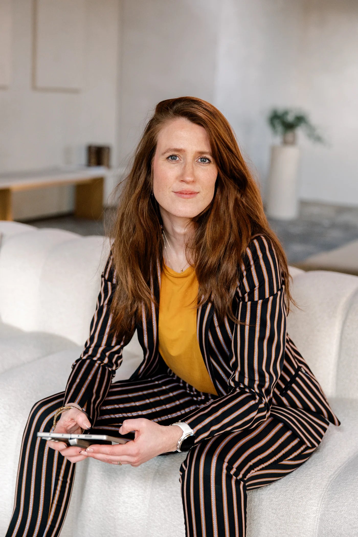 Margot van Lieshout relaxed on the sofa with her phone, wine branding expert and digital strategist